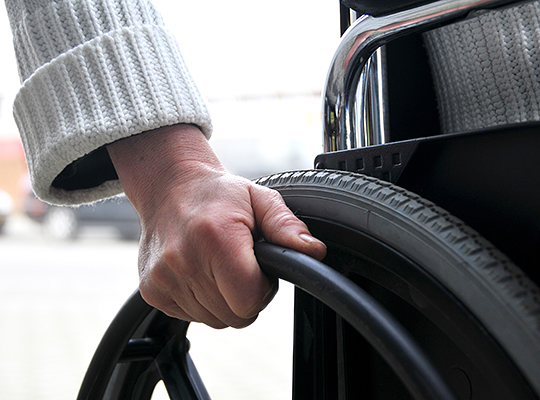 Hand moving the wheel of a wheelchair