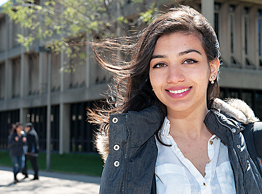 Young woman smiling outside lecture hall