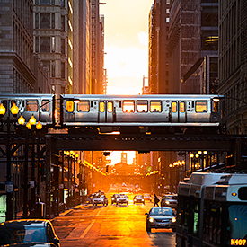 L train passing in front of sunset