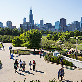 People walking in a plaza with skyline in the background