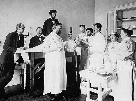 Old photo of a group of men performing an operation