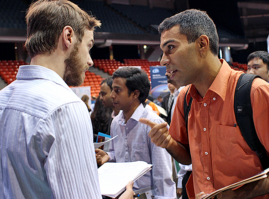Student talking with employer at job fair