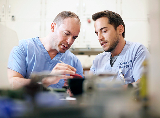 Man showing dental mold to younger man