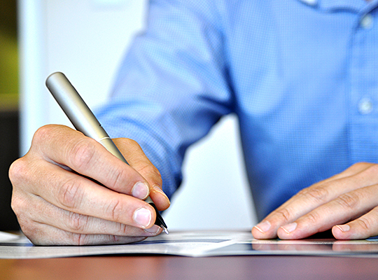 Man holding pen and filling out paperwork